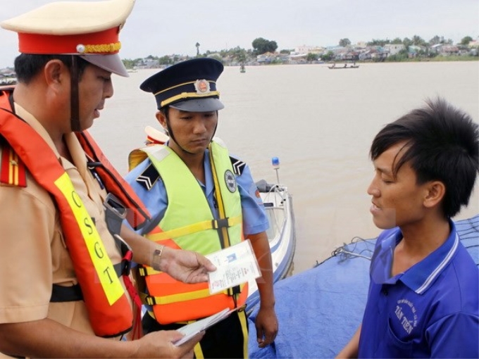 Cảnh sát giao thông đường thủy An Giang kiểm tra bằng lái, giấy phép sử dụng phương tiện giao thông đường thủy trên sông Châu Đốc. (Ảnh: Hoàng Hải/TTXVN)